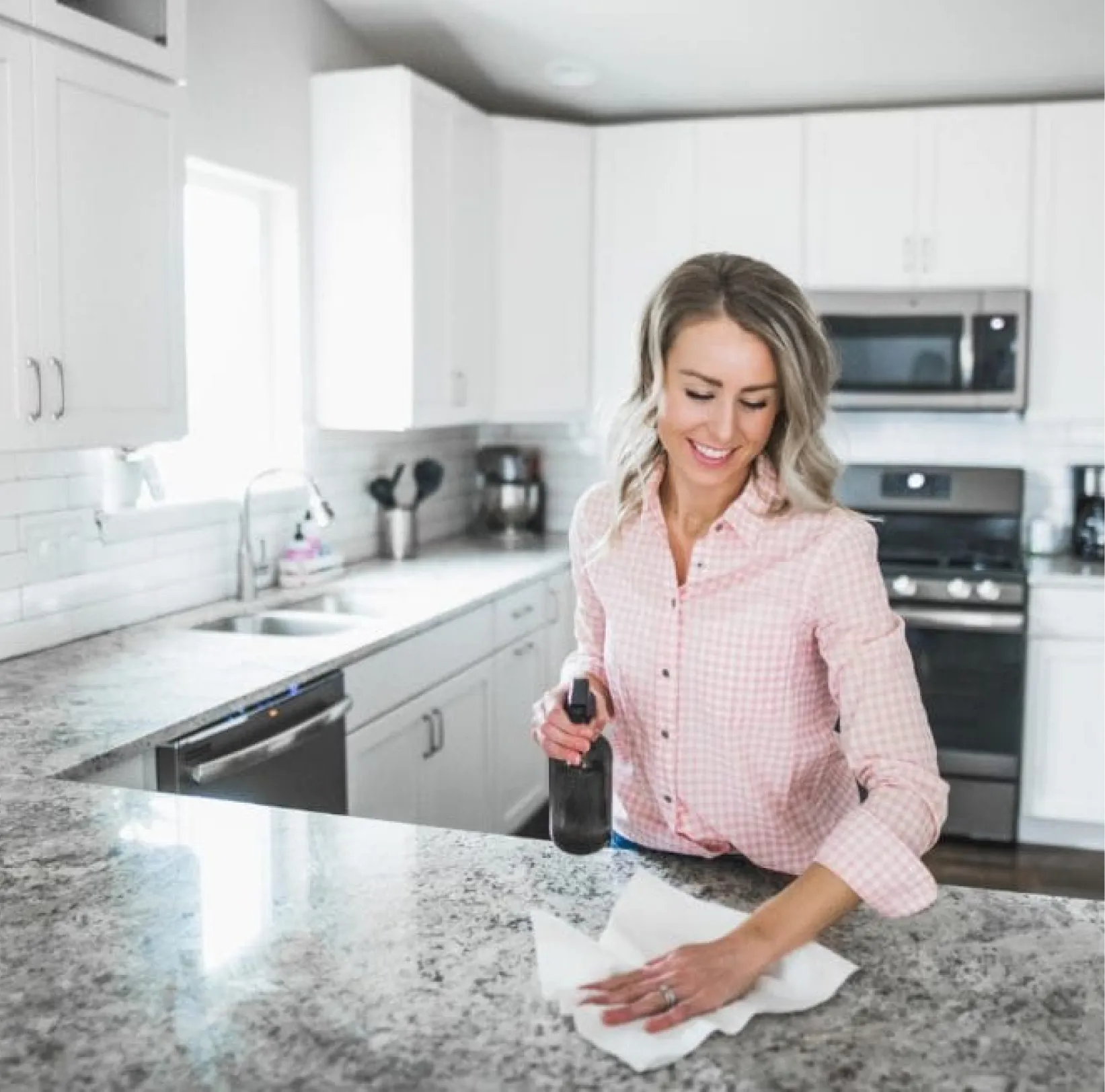 White marble kitchen island with grey veining, black faucet, and a built-in sink under bright lighting.